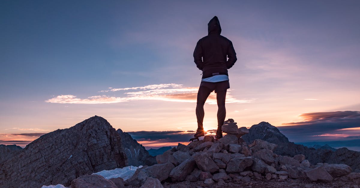 person standing on rock formation during golden hour